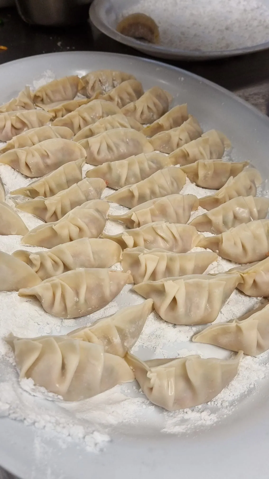 Dumplings being made in the kitchen at Hong Kong Restaurant, showcasing traditional Cantonese cooking techniques